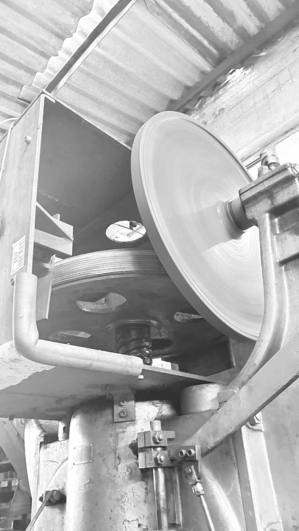 Close-up of a spinning flywheel on press equipment